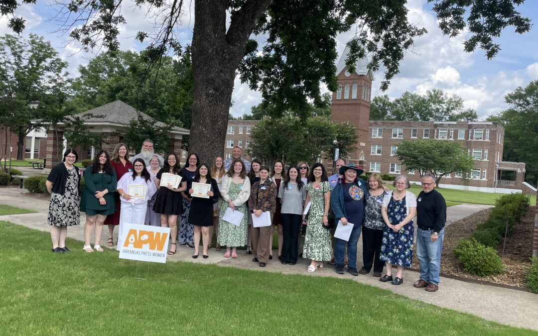 A group of Arkansas Press Women members takes a group photo in front of a tree at Central Baptist College.