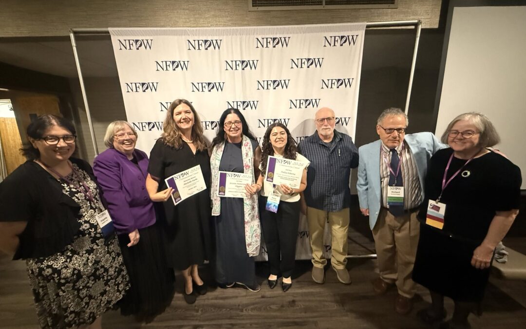 Group of people stand holding their awards in front of a NFPW backdrop.